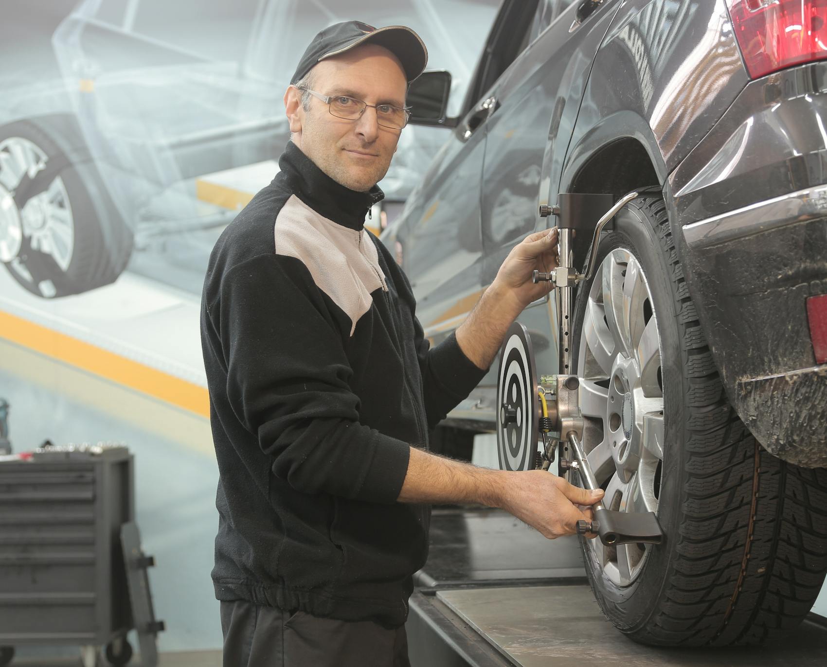 A technician performing a wheel alignment at Ismael and Son